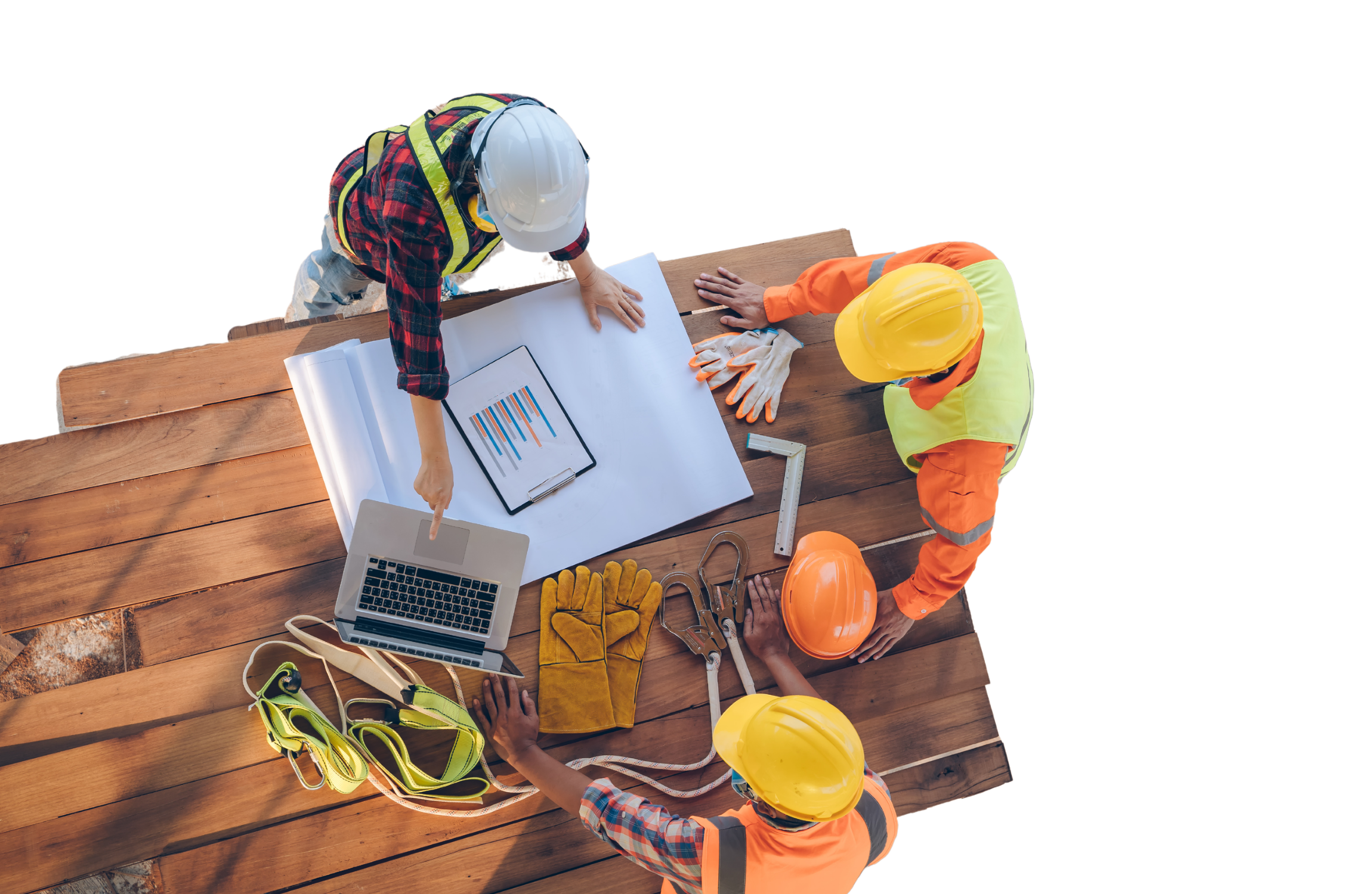 High-angle view of three construction professionals in hard hats and safety vests reviewing blueprints, a laptop, and data charts on a wooden workspace