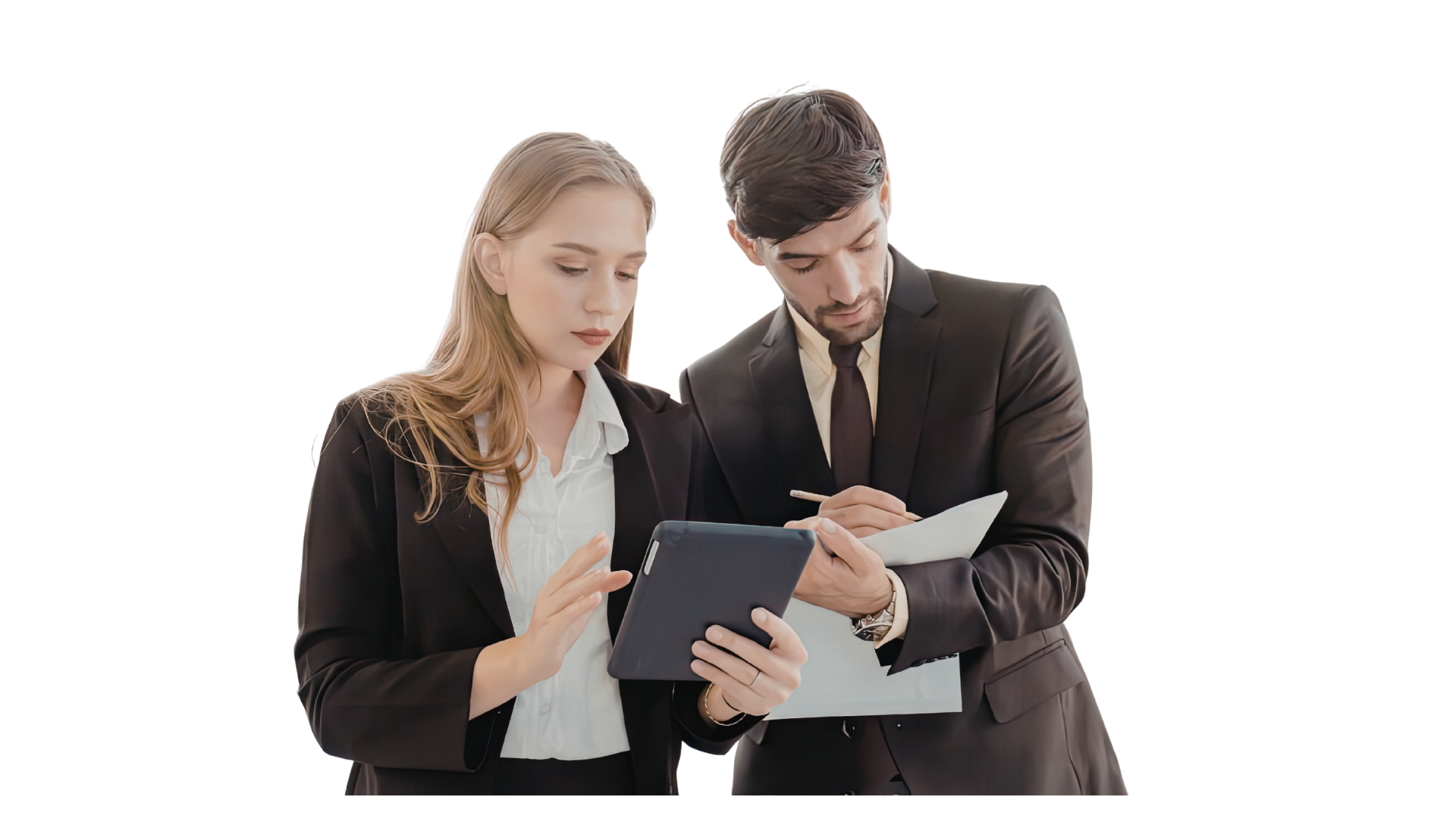 Professional Business Consultation and Digital Data Review A woman and a man in professional business attire standing against a black background. The woman is looking at and touching a tablet she is holding, while the man looks on and takes notes on a clipboard.