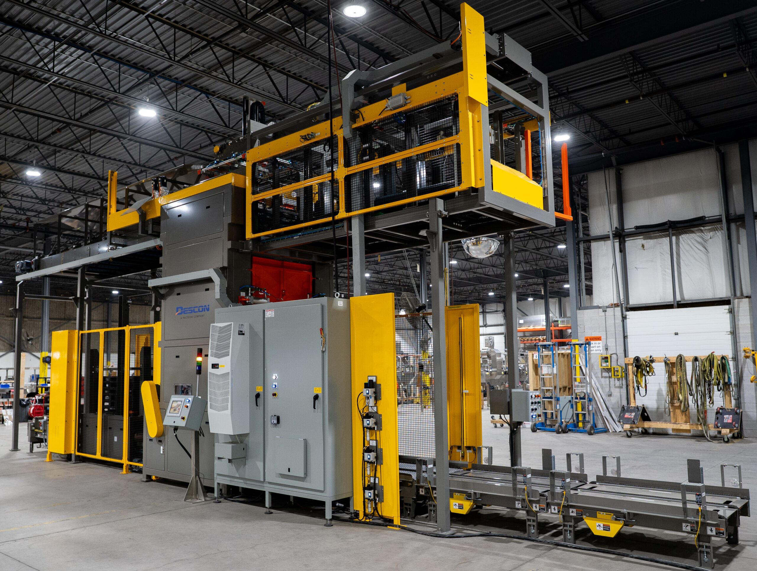 Descon depalletizer system installed on a manufacturing floor with safety guarding and control panels