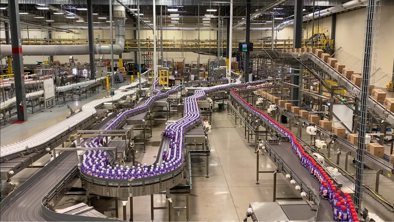 Descon conveyor system transporting bottled beverages through a high-volume production facility